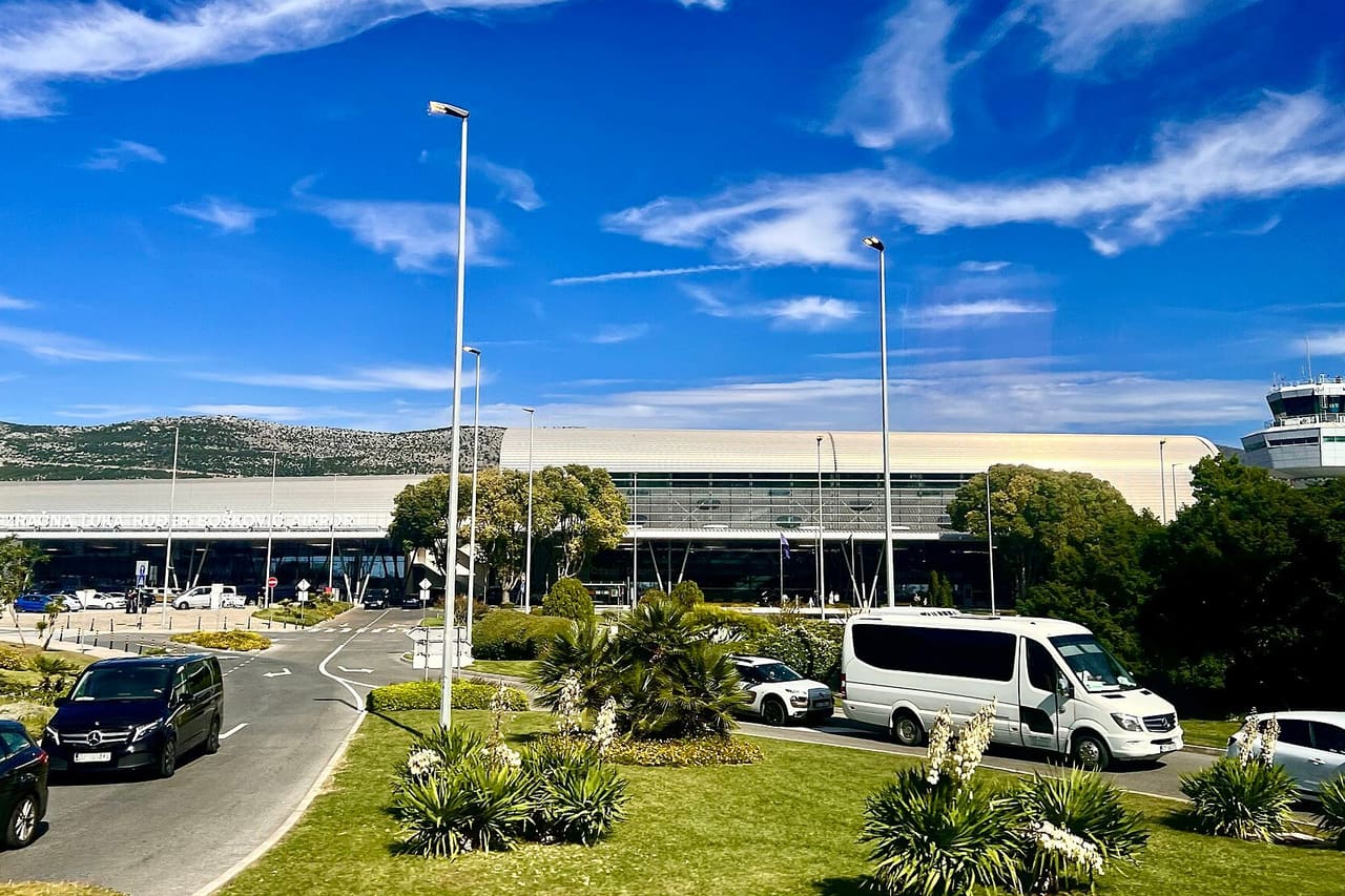 Terminal building at Dubrovnik Airport (DBV) with vans in the drop-off lane